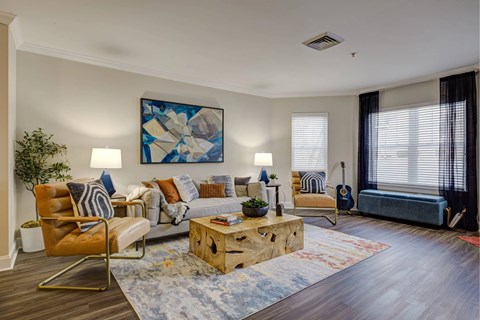 A living room with a wooden floor and a large painting on the wall.