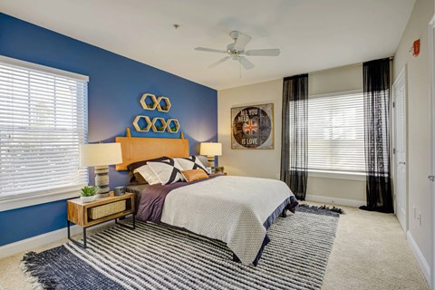 A bedroom with a bed, nightstand, and a ceiling fan.