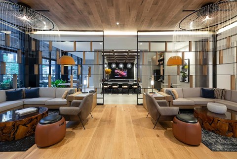 A modern living room with a wooden floor and a large TV in the background.