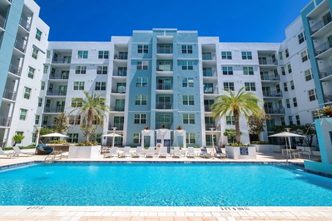 A large white building with a pool in front.