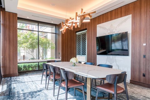 A dining room with a large table and chairs.