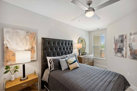 A bedroom with a large bed and a ceiling fan.