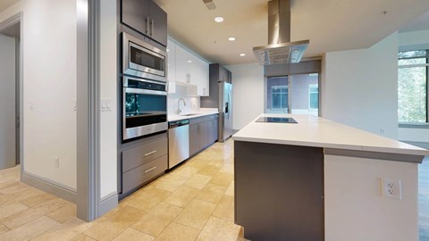 A modern kitchen with a large island and stainless steel appliances.