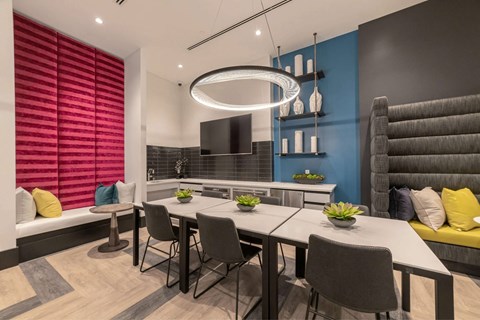 A modern dining room with a long table and grey chairs.