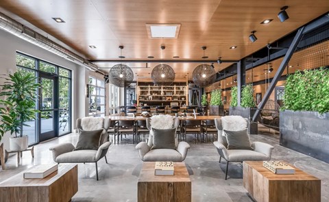 A modern living room with a wooden ceiling and grey chairs.