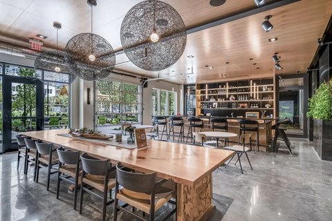 A modern dining room with a long wooden table and chairs.