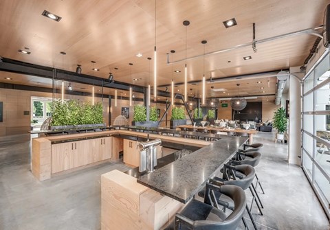 A modern kitchen with a long counter and bar stools.