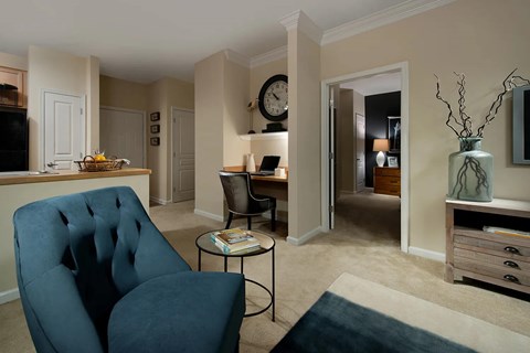 A blue chair sits in a living room with a coffee table in front of it.