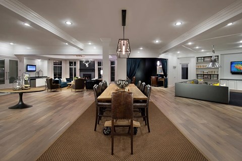 A dining room with a long table and chairs.