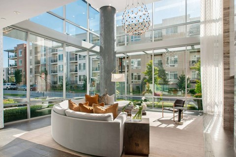 A modern living room with a large white couch and a tall column.