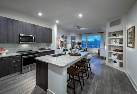 A modern kitchen with dark wood cabinets and a white island.