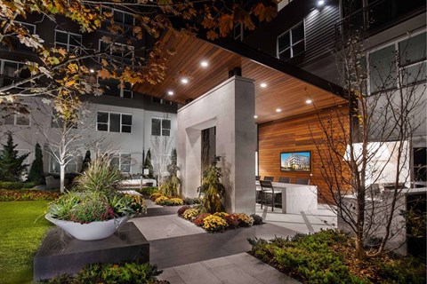 A modern house with a wooden exterior and a garden in front.