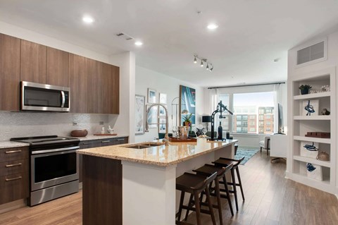 A modern kitchen with a large island and wooden cabinets.