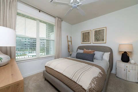 A bedroom with a large bed and a ceiling fan.