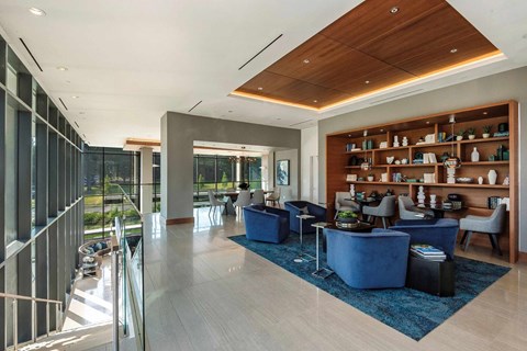 A modern living room with a blue rug and a wooden ceiling.