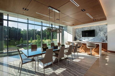 A modern dining room with a glass table and chairs.