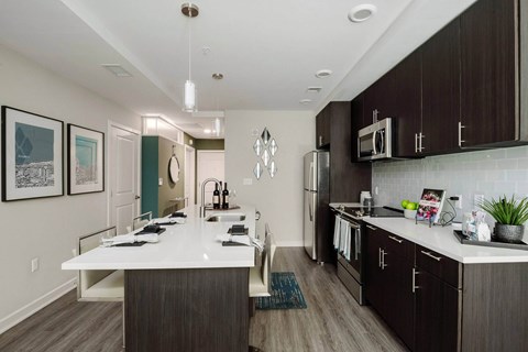 A modern kitchen with dark wood cabinets and white countertops.
