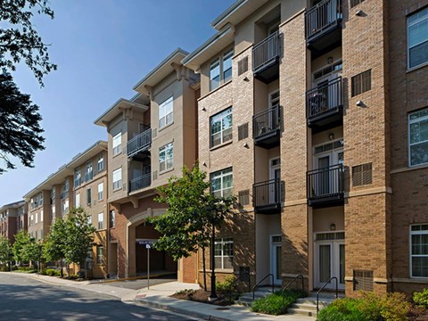 A row of apartment buildings with balconies and doors.