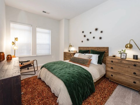 A bedroom with a bed, a dresser, and a window.