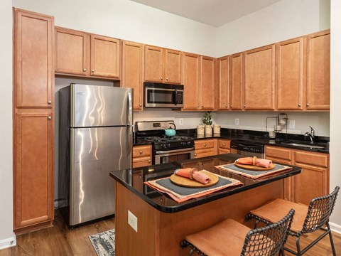 A kitchen with wooden cabinets and a black countertop.