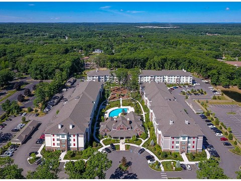 An aerial view of a resort with a swimming pool and a parking lot.