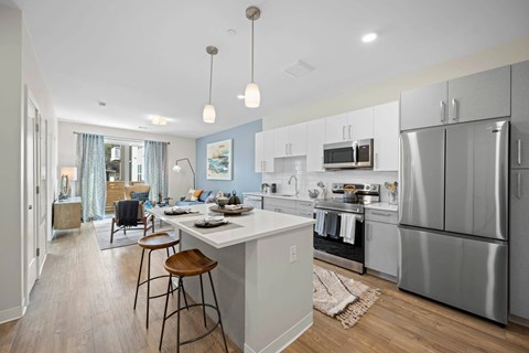 A modern kitchen with a large island and stainless steel appliances.