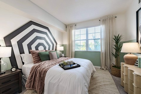 A bedroom with a large bed and a tray of flowers on it.