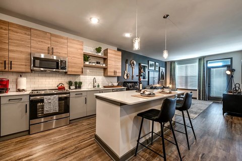 A modern kitchen with a center island and stainless steel appliances.