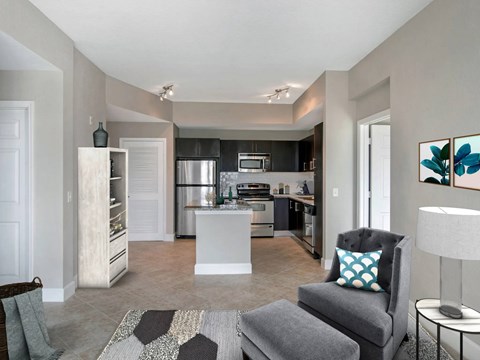 A modern kitchen with a grey chair and a white island.