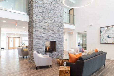 A modern living room with a stone pillar and a fireplace.