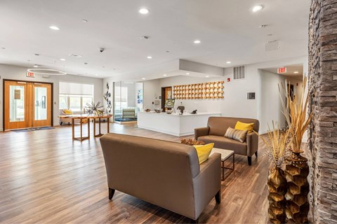 A living room with a brown couch and a stone pillar.