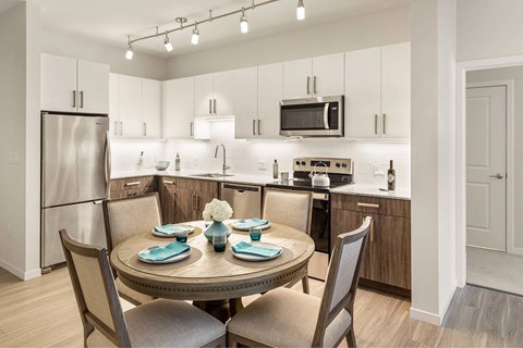 A modern kitchen with a round table set for two.