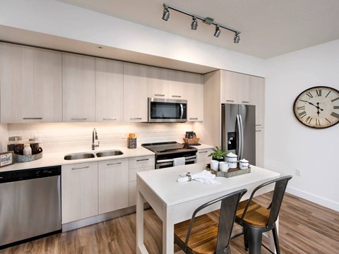 A modern kitchen with a white table and chairs.