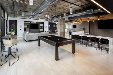 A modern open plan office with a pool table in the middle.