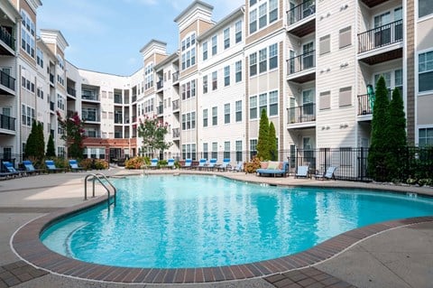 A large swimming pool in front of apartment buildings.