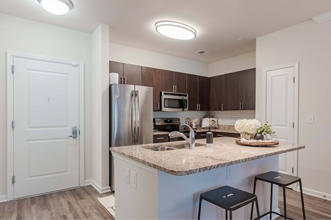 A kitchen with a granite countertop and stainless steel appliances.