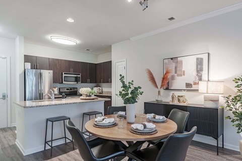A modern kitchen with a dining table set for two.