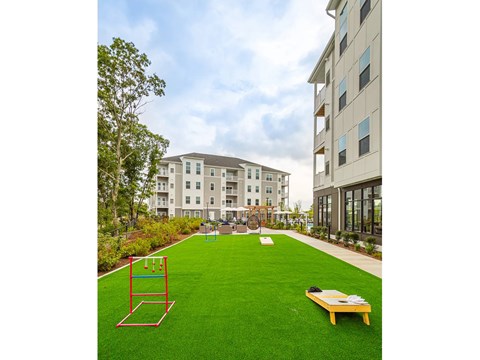 A playground with a swing set and a bench in the middle of a grassy area.
