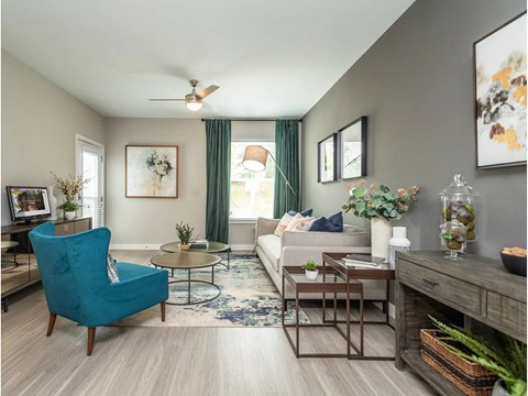A living room with a blue chair and a white couch.