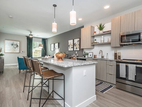 A modern kitchen with a large island and bar stools.
