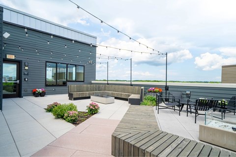 A patio area with a bench, table, and a building in the background.