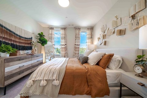 A bedroom with a large bed and a window with curtains.
