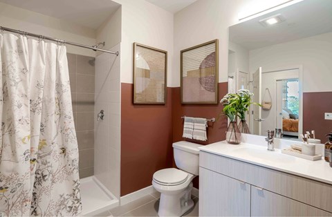 A bathroom with a toilet, sink, and shower.