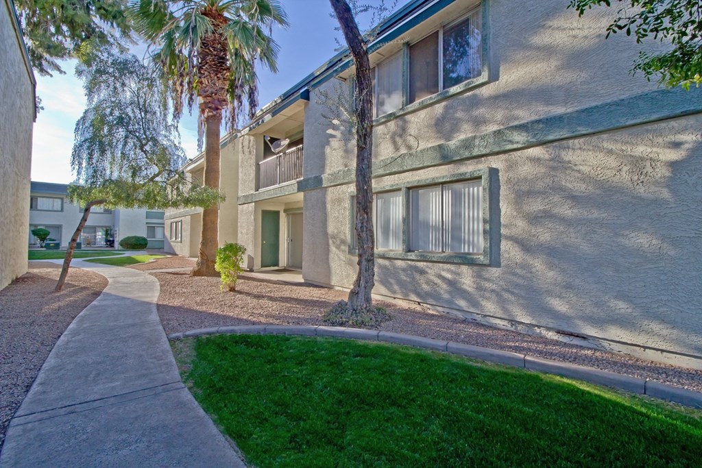 an exterior view of a building with a sidewalk and grass