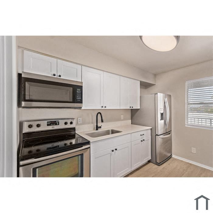 A kitchen with white cabinets and stainless steel appliances.