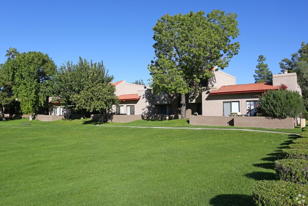 a lawn in front of a building with trees