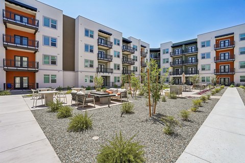 Apartment complex with a gravel garden in front.