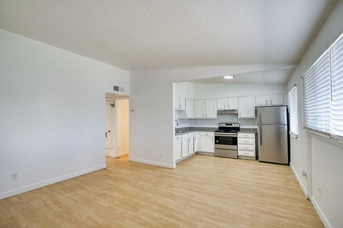 A kitchen with white cabinets and a stainless steel refrigerator.