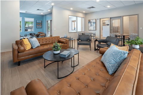 A living room with brown leather couches and a coffee table.