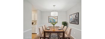 A dining room with a wooden table and chairs.